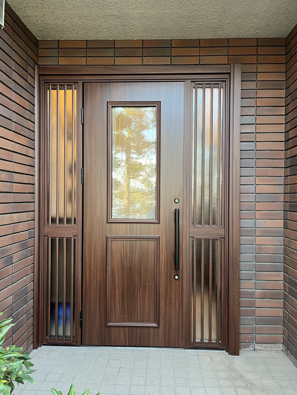 華やかなデザインガラスで木調色が美しさを際立てる玄関