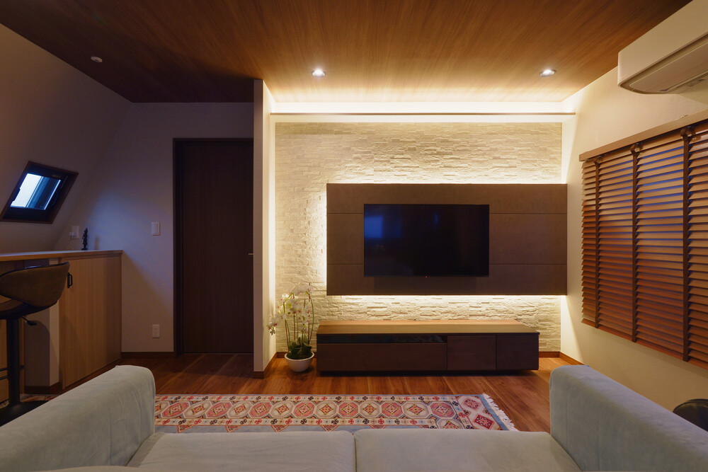 TV背面のデザイン壁と間接照明が空間を彩ります。