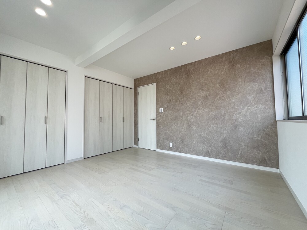 奥様の寝室には、シックな大理石調のクロスを取り入れました。