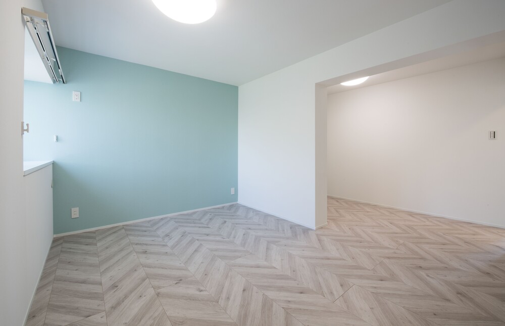 アクセントカラーの水色が映える空間。ヘリンボーン調の床がおしゃれな空間を演出しています。