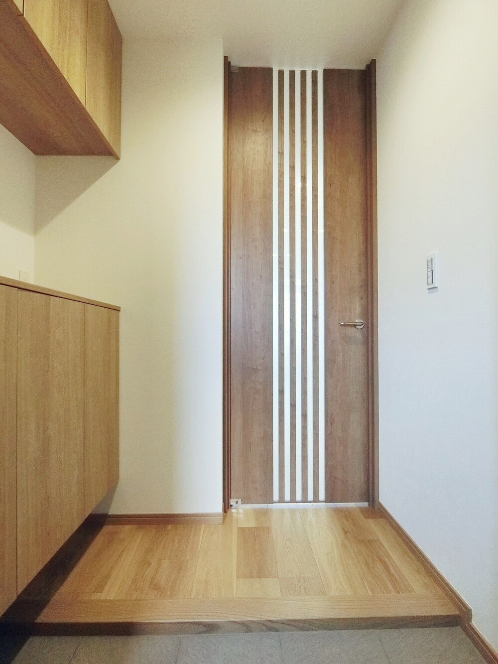 リビング側から玄関へと光を導く、ガラス入りのハイドア。玄関ドアの採風機構とハイドアを開けると、家じゅうに風を通すこともできます。