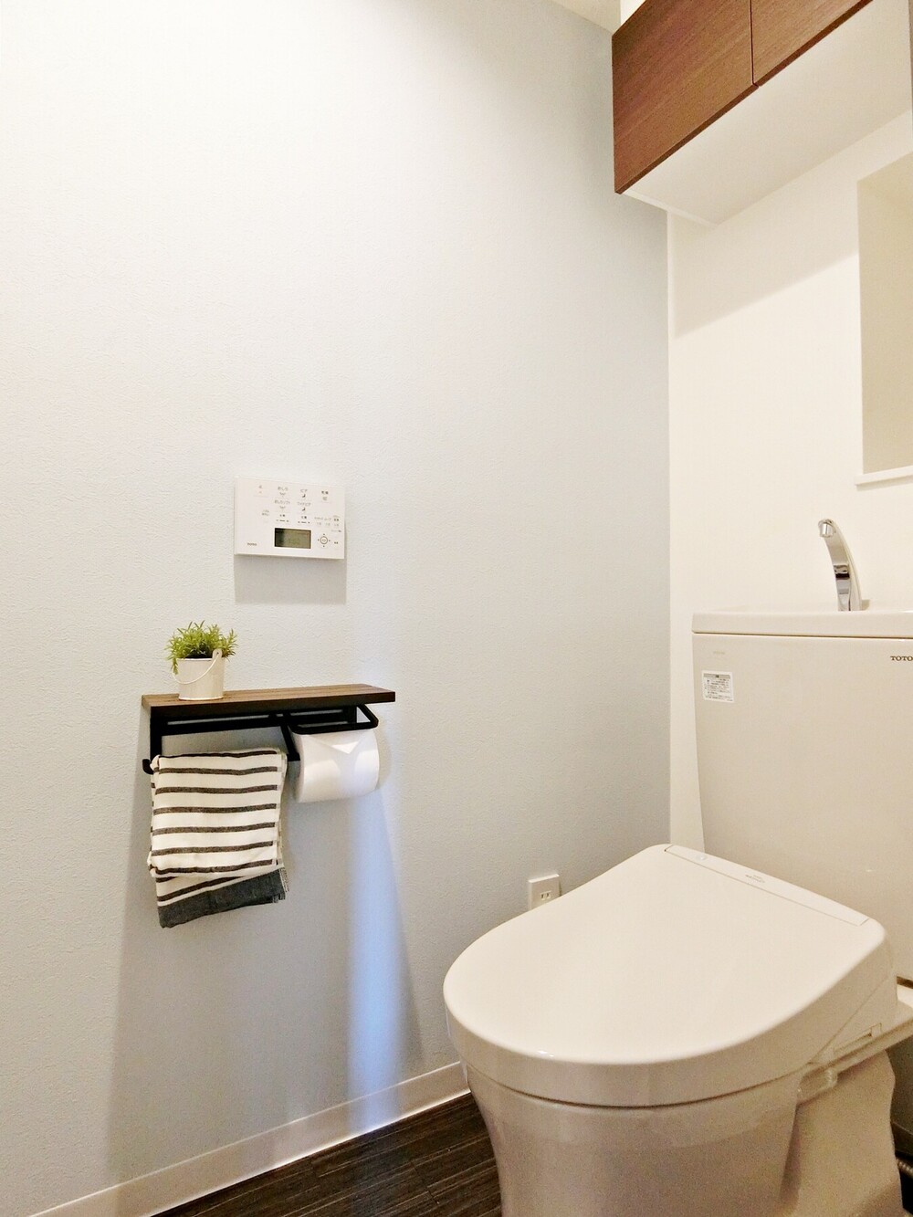 ペールブルーのアクセントクロスで、清潔感のあるトイレ空間に。他の居室にもテーマカラーである寒色を使い、住まい全体の統一感を演出しています。