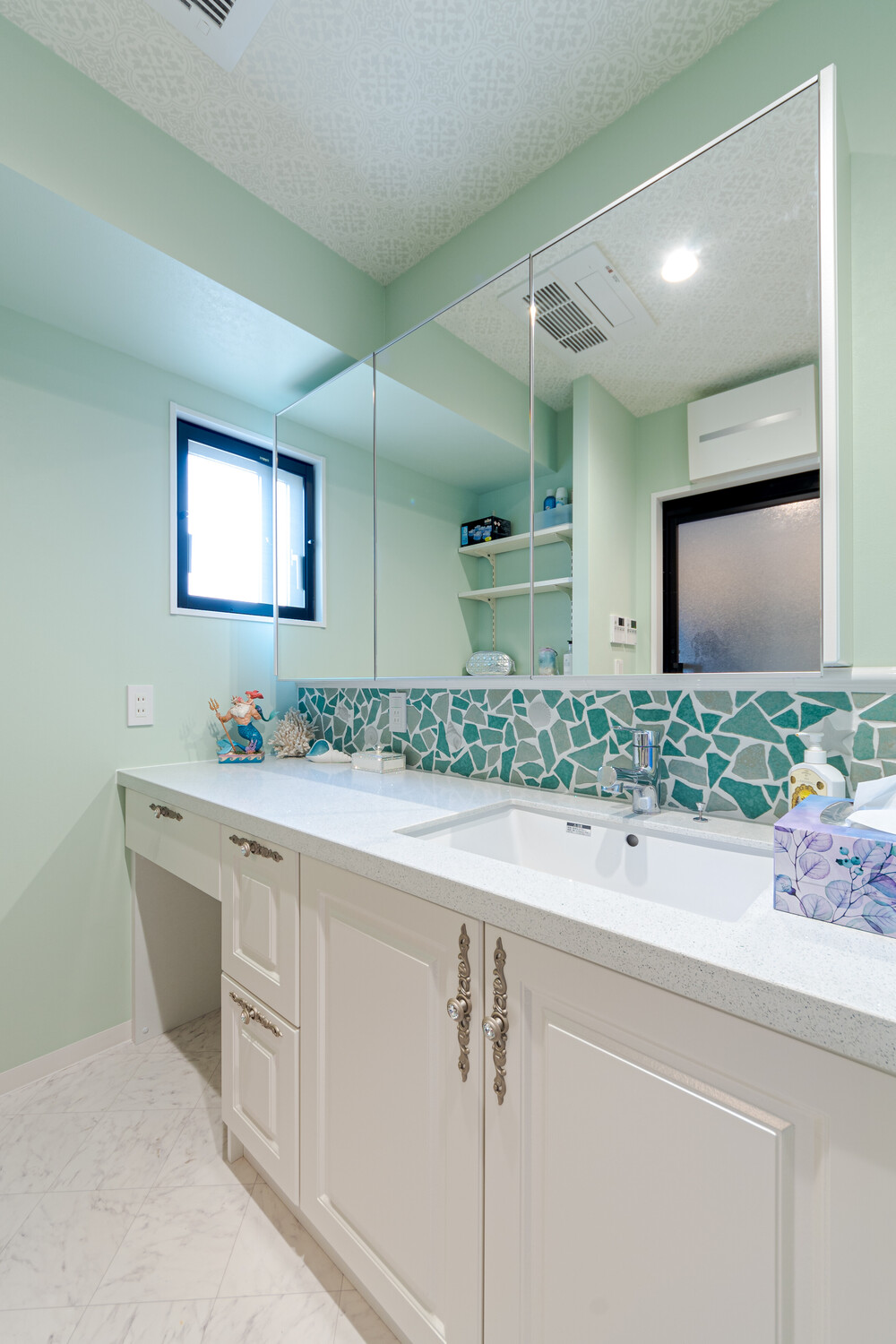 洗面室内のレイアウトを変更することで、広々とした幅180㎝の洗面カウンターを設置。もちろん鏡もワイドタイプなので、二人ゆったり並べます。 また造り付けの可動棚のおかげで、収納家具を置くことなく、スッキリとした洗面室を保つことができるようになりました。