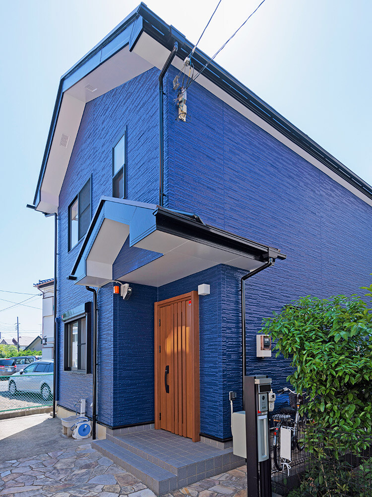 奥様お気に入りのネイビーブルーの外壁に、ご主人こだわりの木目調のドアが美しく映える、洗練された外観デザインです。