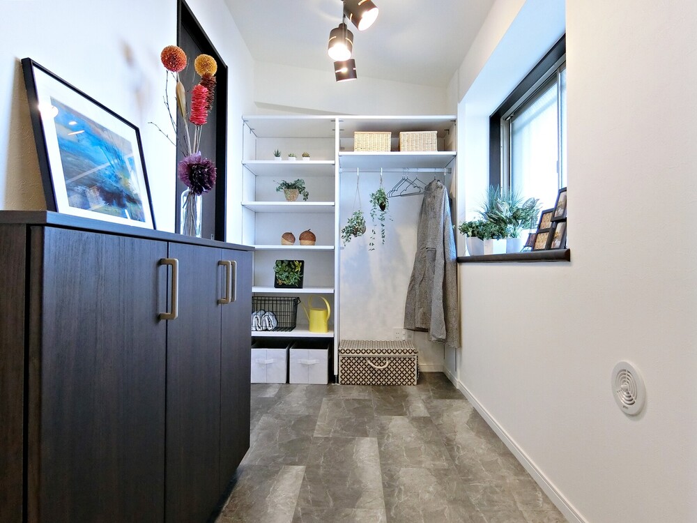 シューズインクロークには、コートを掛けられるハンガーや、帽子などの小物を収納できる棚を設置。靴をサッと出し入れできる、カウンタータイプの下駄箱も設置しました。