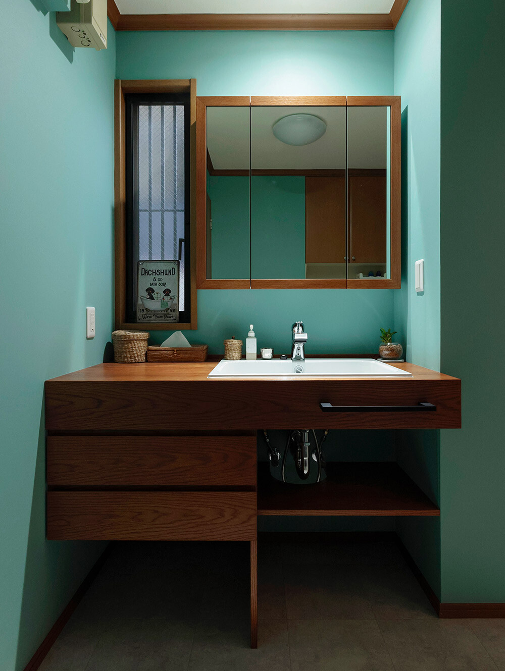 天井付近から壁面を伝って降りる柔らかな光が、鮮やかなブルーの壁紙をムラなく照らし出し、空間に豊かな奥行きを与えています。