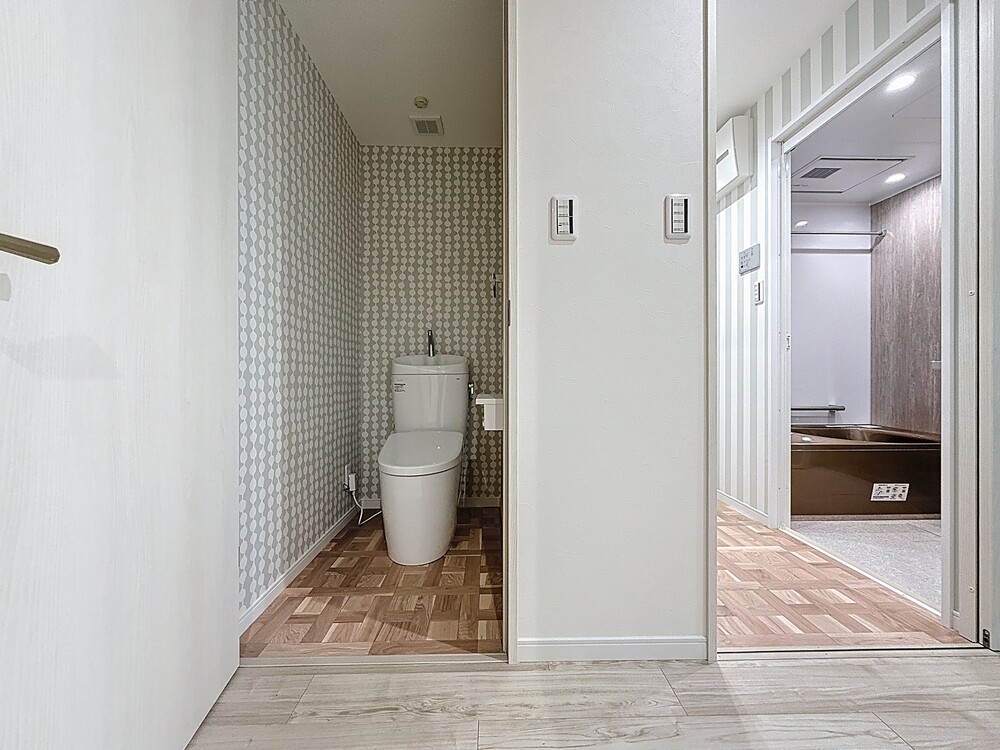 コンパクトなトイレには、北欧柄の優しい色合いのクロスを取り入れてホッとする空間に。